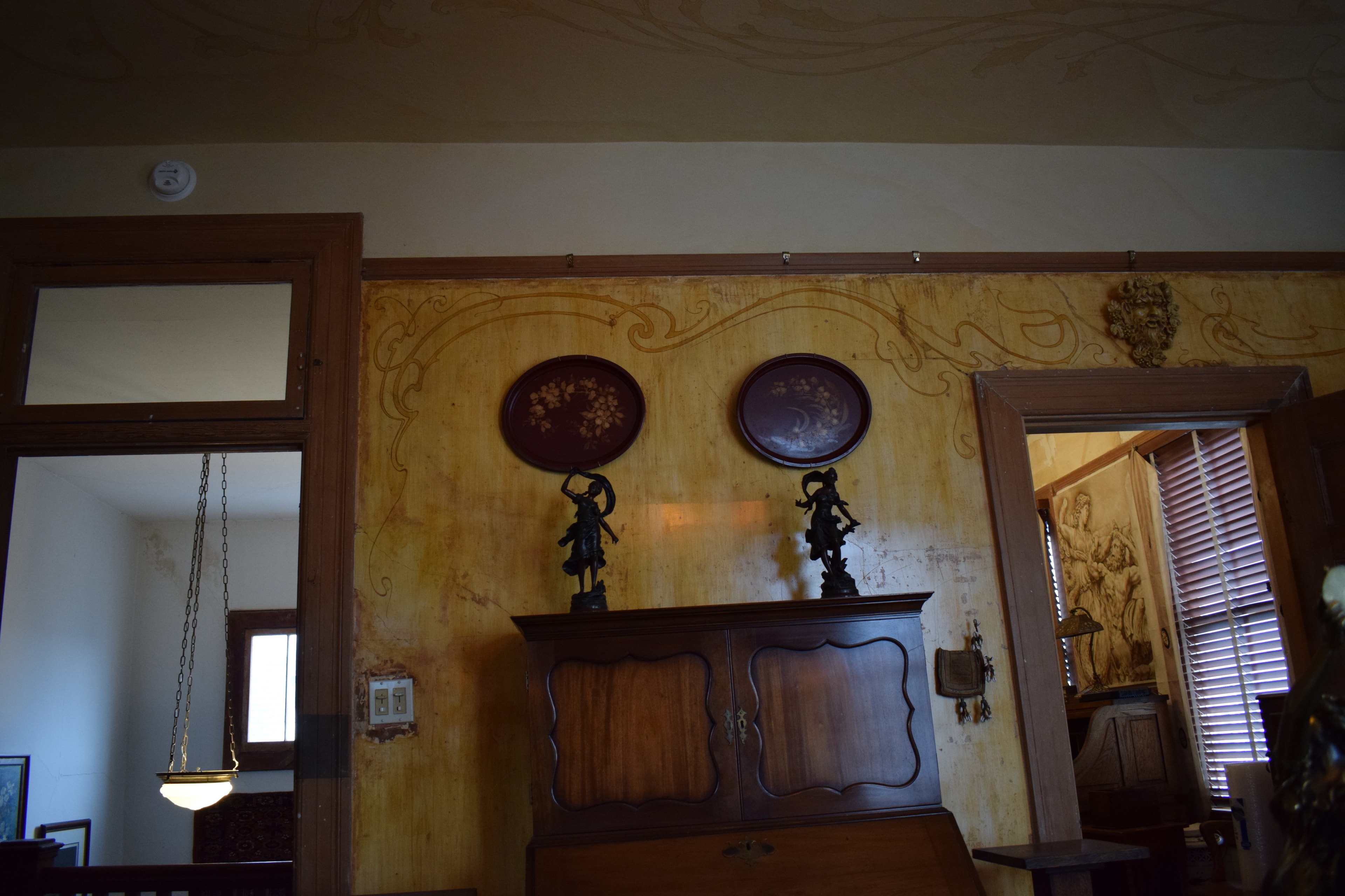 Art Nouveau wall frieze with flowing organic line work, view through doorways to adjoining rooms