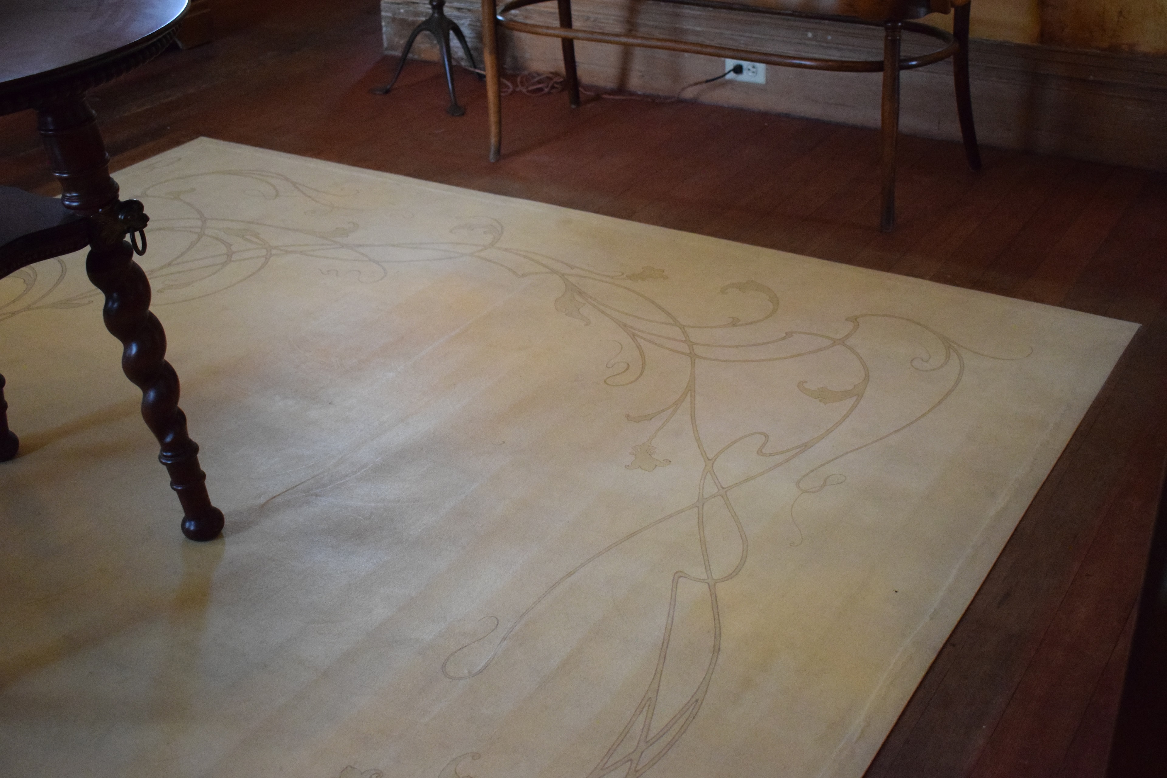 Painted floor cloth with Art Nouveau line work in warm ivory and gold, matching the wall and ceiling treatment