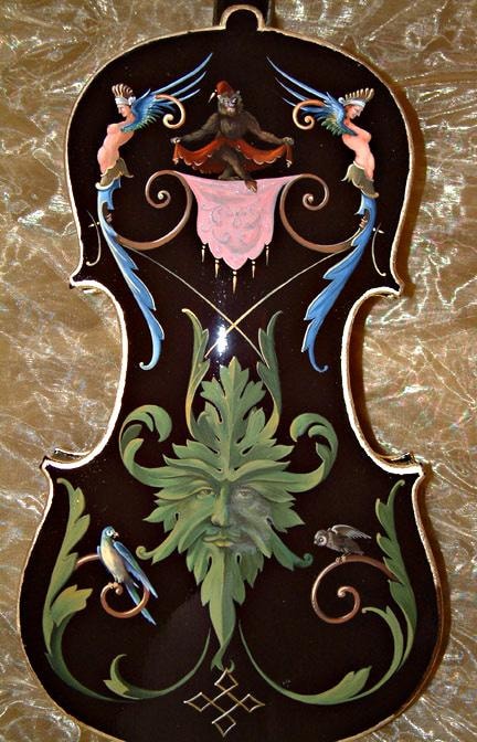 Back of the violin showing the grotesque composition with Green Man, monkey, and parrots