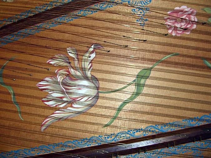 Soundboard detail of the Donzelague harpsichord — tulip and botanical painting amid scrollwork
