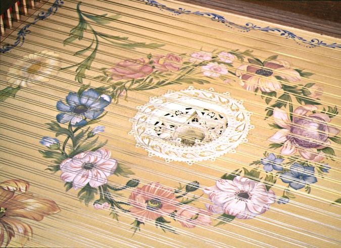Vaudry 1681 soundboard — floral painting in period pigments surrounding a hand-cut three-tier parchment rose