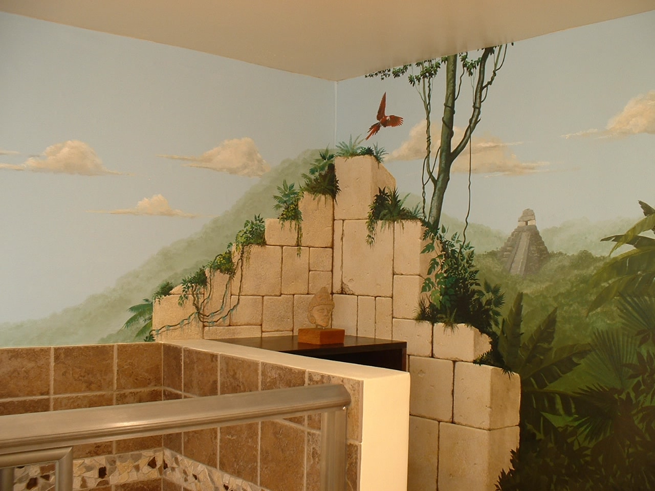 Corner view of Mayan bathroom mural showing jungle panorama wrapping both walls